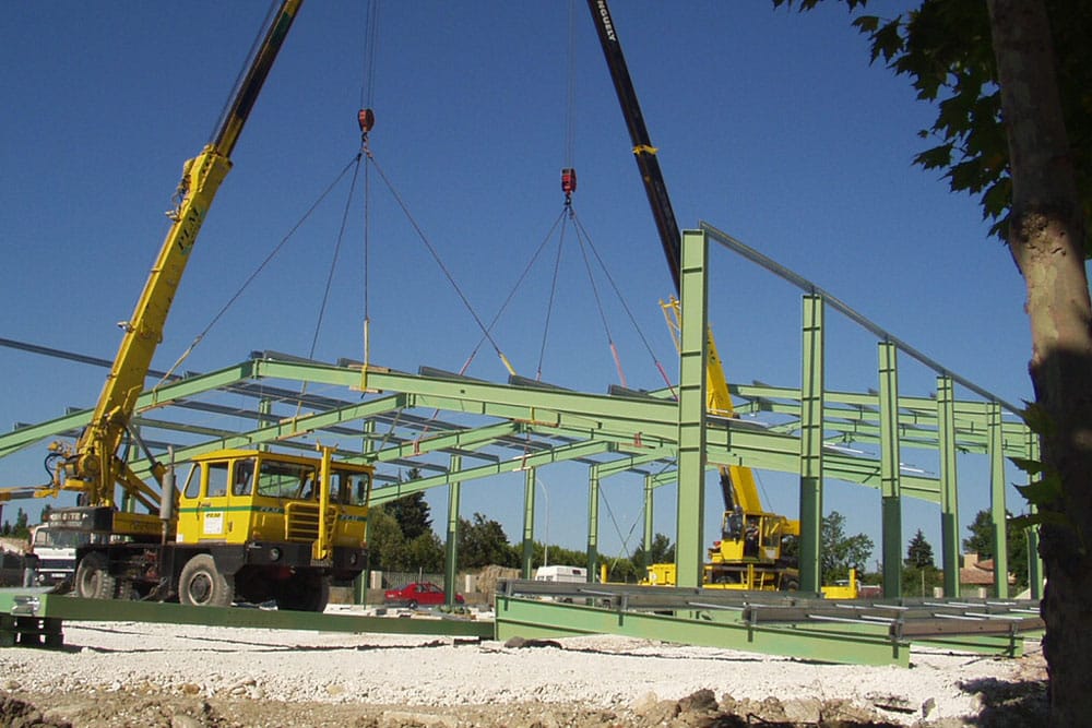 Charpente acier en cours de pose avec une grue