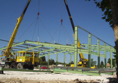 Charpente acier en cours de pose avec une grue