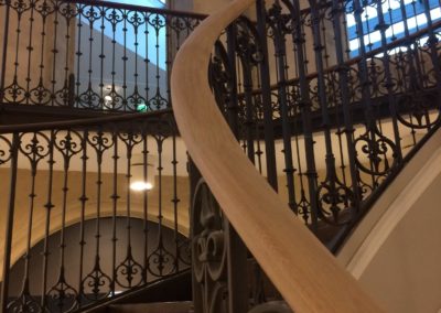 Escalier tournant du 19e siècle rénové avec garde-corps en fonte