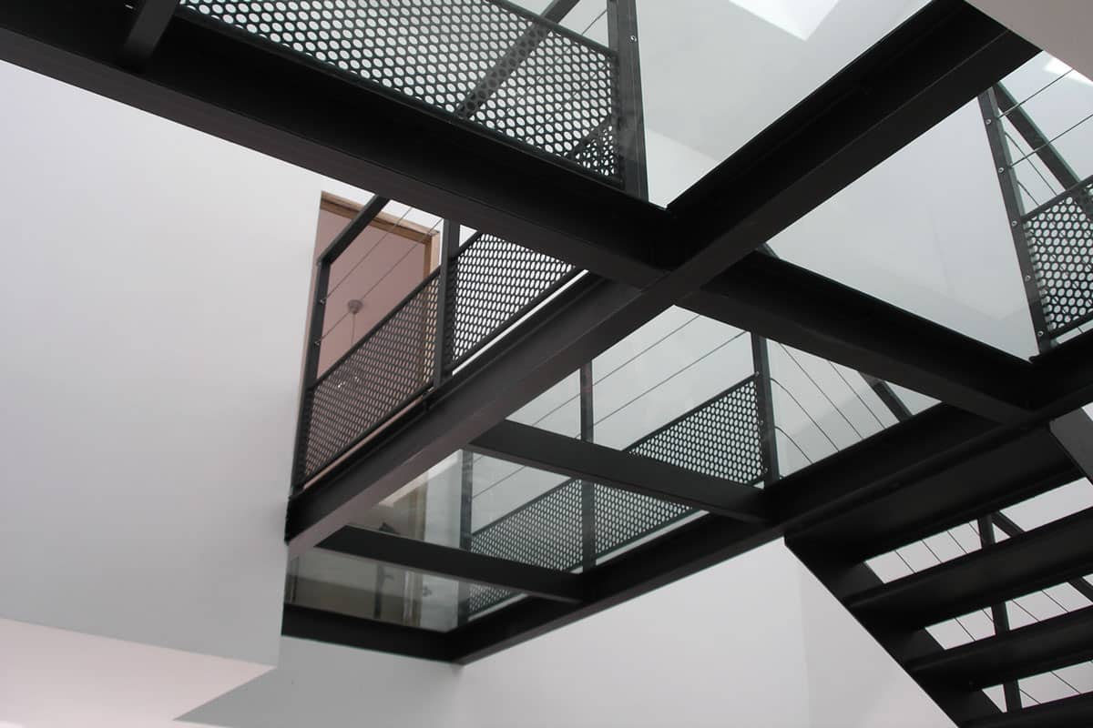 Passerelle intérieure en acier avec platelage en verre et garde-corps à fils